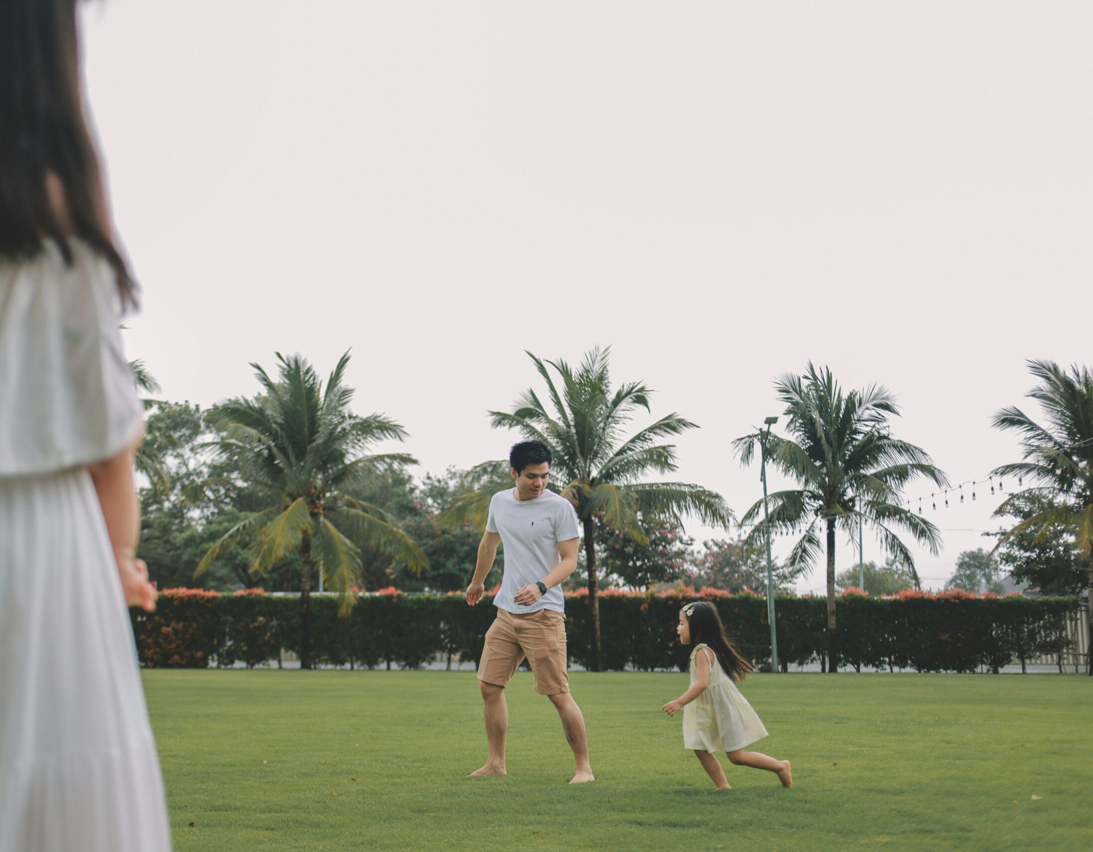 Family playing catch on a grassy field